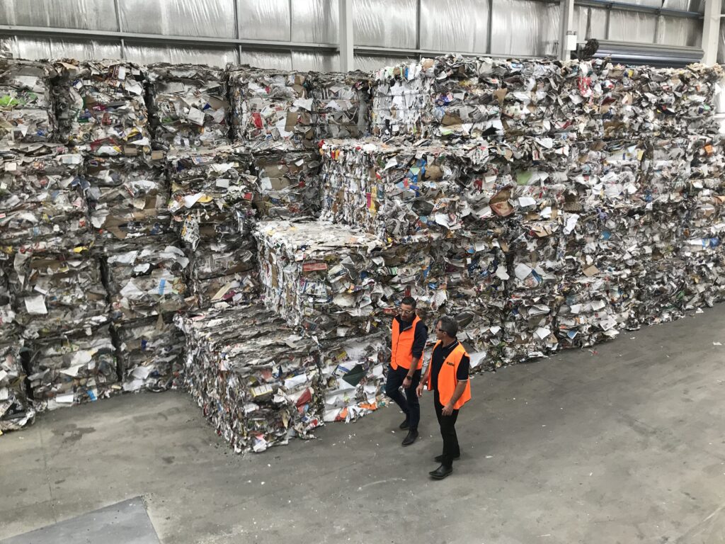 NAWMA staff inspecting mixed paper bales